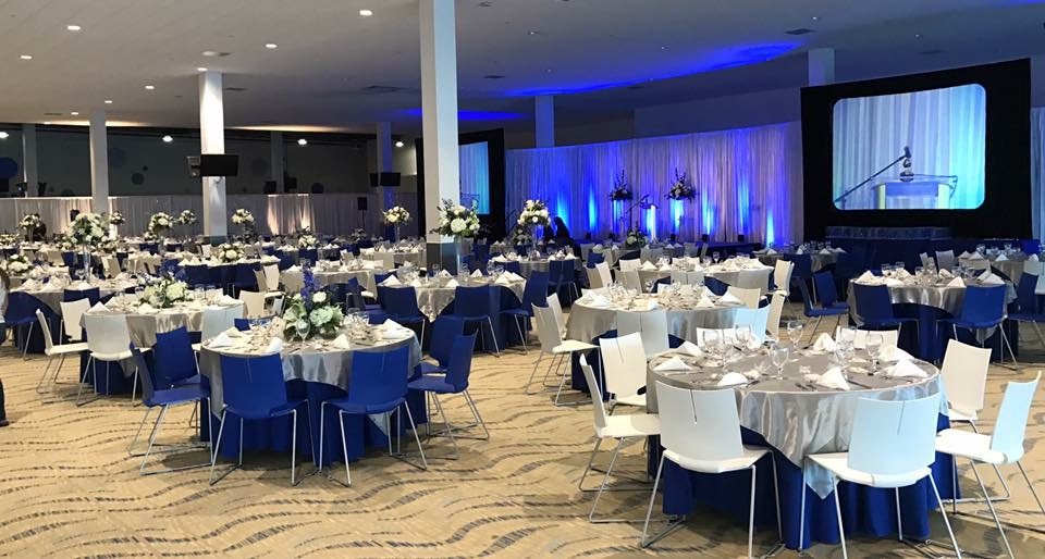 Gala dinner hall set with round tables and a stage